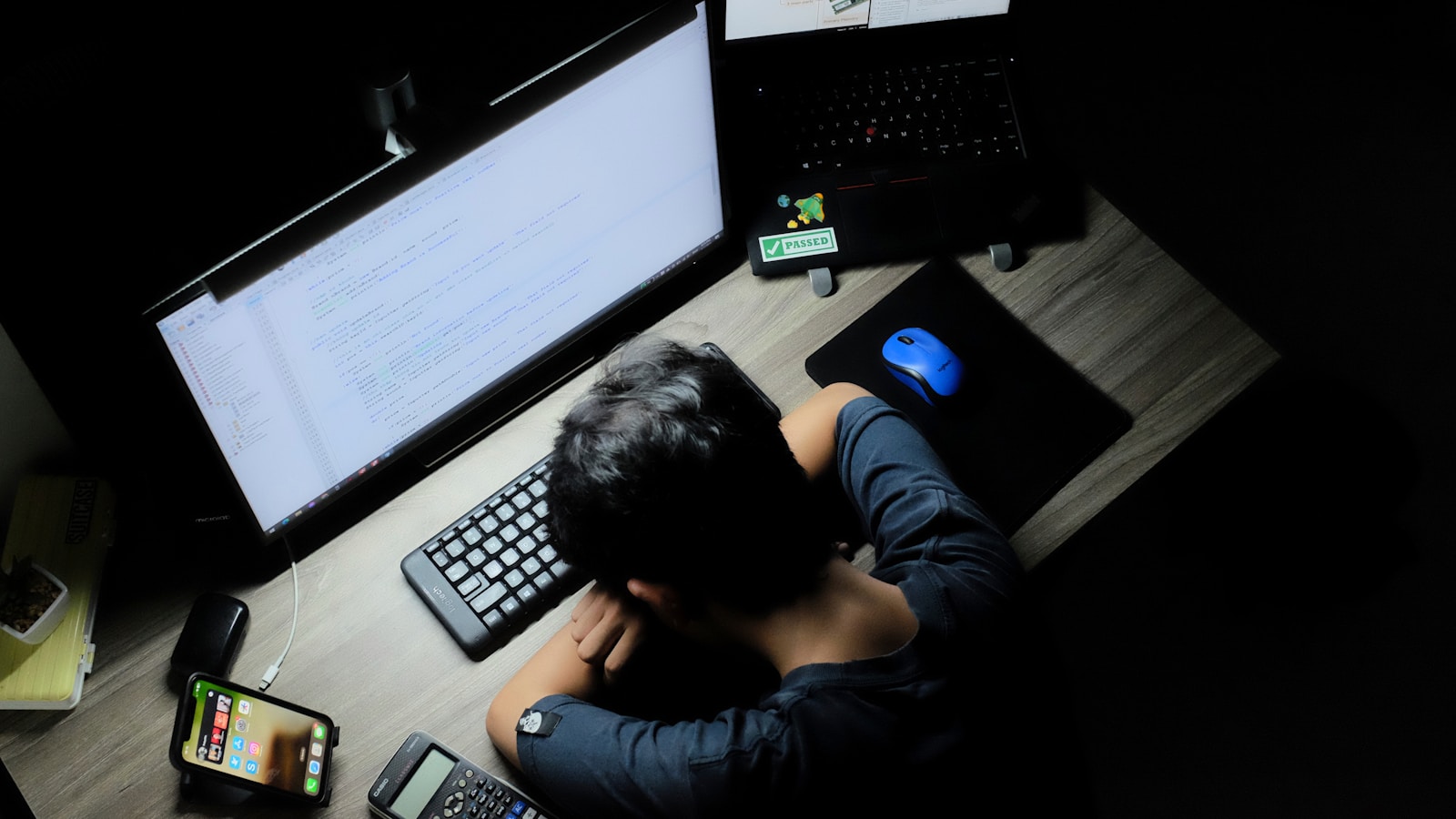 a man sitting in front of a computer monitor